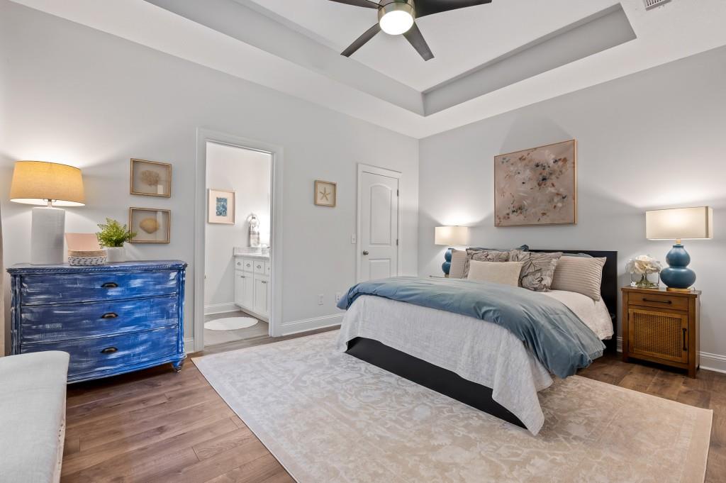 423 Palmetto Street St. Simons, GA 31522 - Photo 14 of 38 a spacious bedroom with a bed and a chandelier