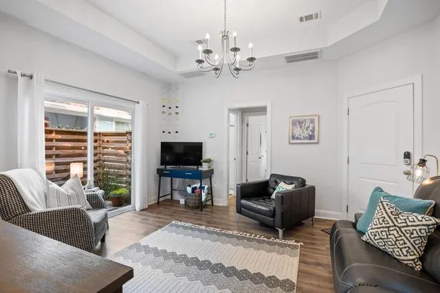 a living room with furniture a flat screen tv and a window