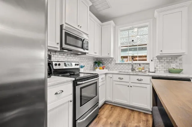a kitchen with stainless steel appliances granite countertop a stove microwave and sink