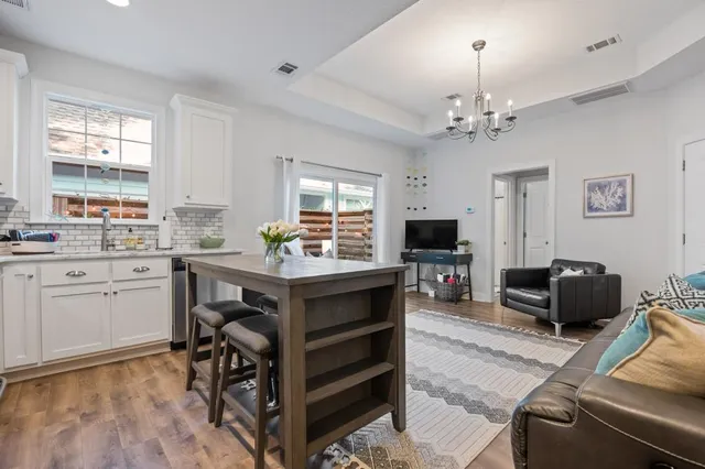 a living room with furniture flat screen tv and window