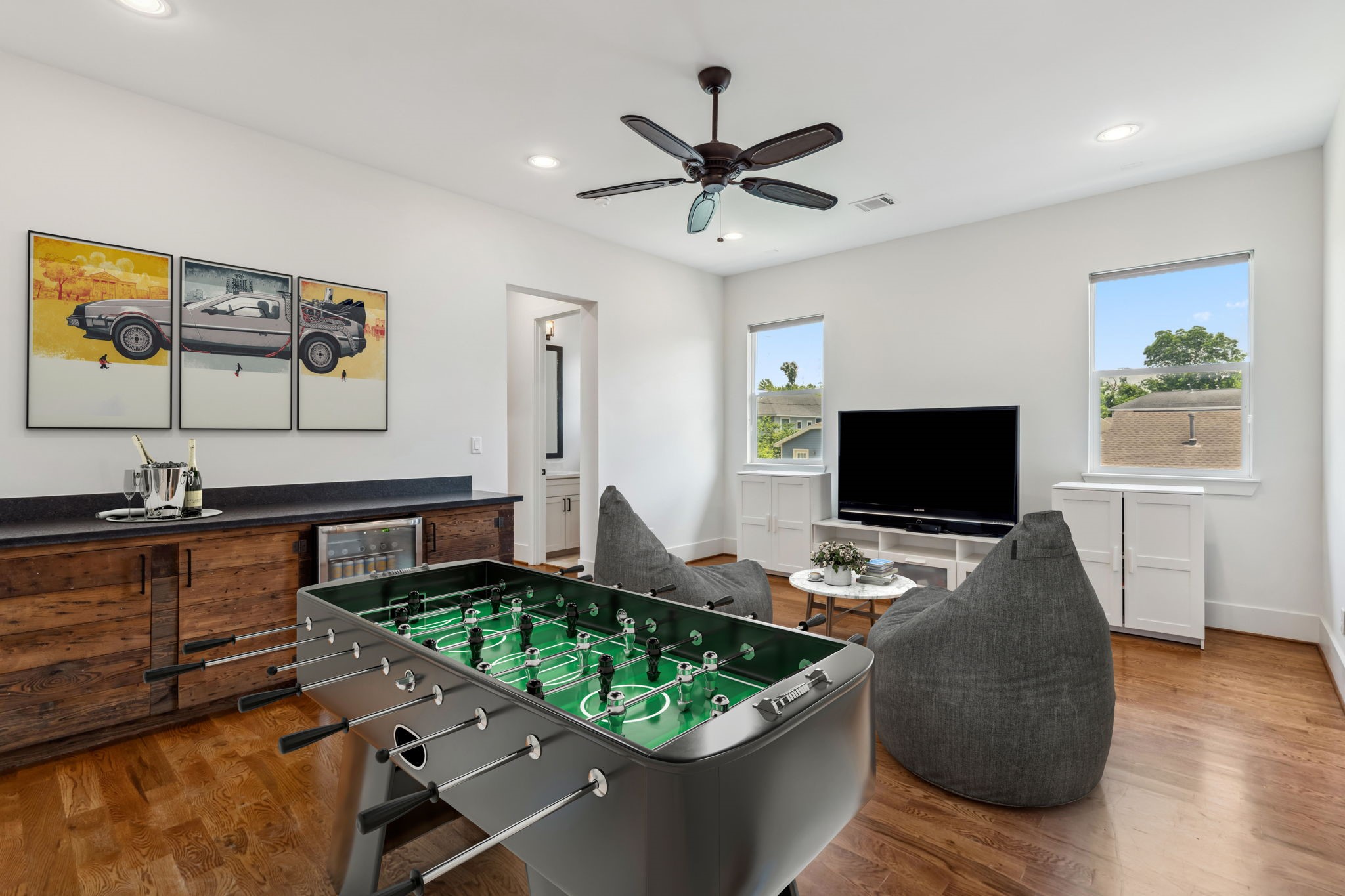 815 East 27th Street Houston, TX 77009 - Photo 16 of 44 Located upstairs, this large game room offers endless possibilities for entertainment & relaxation. Sellers have thoughtfully added a custom built-in bar complete w/beverage fridge & ample storage. Large windows, w/roll-down shades,let in plenty of light, while recessed can lighting & ceiling fan ensure the space is always comfortable. Whether you're watching movies, playing games,or just unwinding,this room is the perfect spot to enjoy time with family & friends.Note photo has been virtually staged.