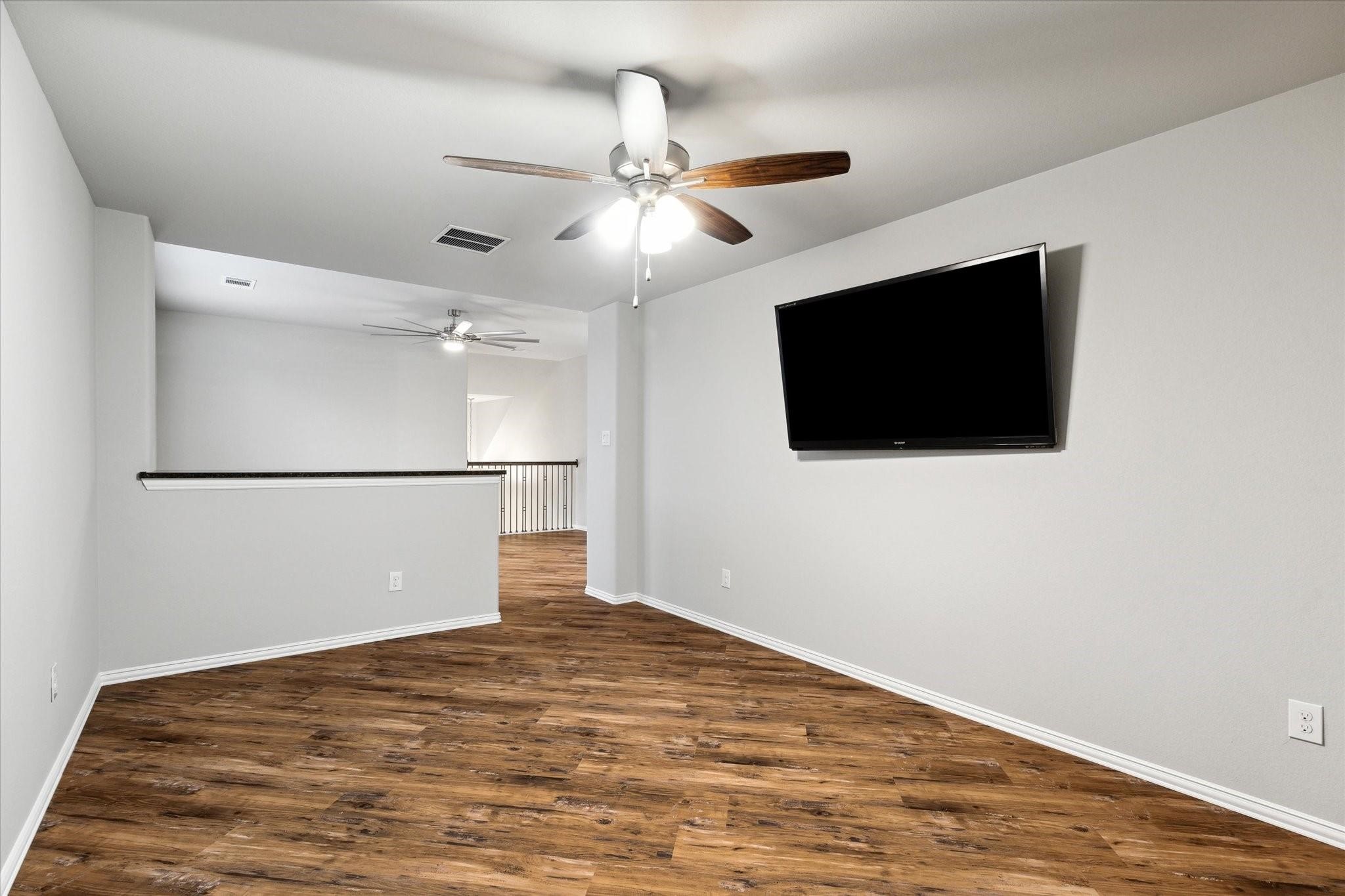 1010 Bat Hawk Court Conroe, TX 77385 - Photo 29 of 50 a view of a livingroom with an empty space and a ceiling fan