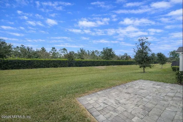 a kitchen with a sink a refrigerator and white cabinets