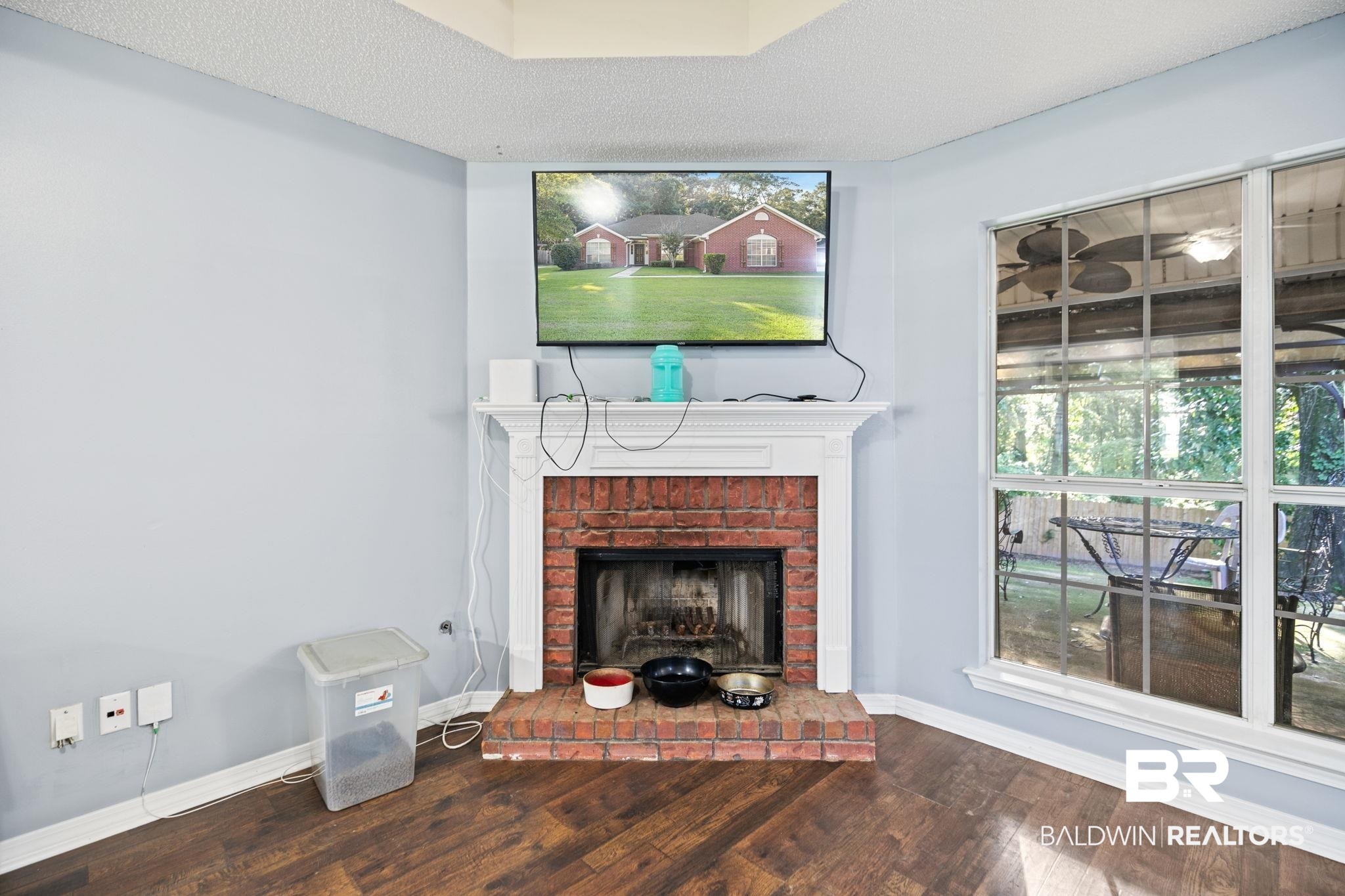 10550 Patrick Avenue Grand Bay, AL 36541 - Photo 12 of 43 Living room with a textured ceiling, wood-type flooring, and a brick fireplace