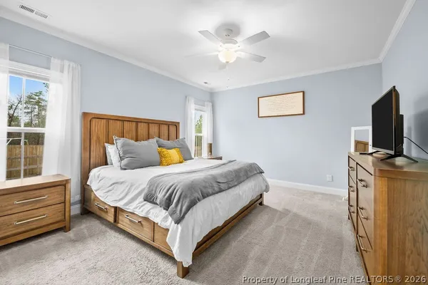 a spacious bedroom with a bed and a flat screen tv