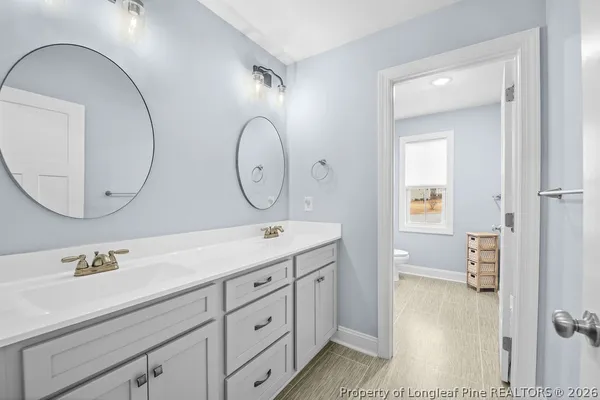 a bathroom with a double vanity sink and a mirror