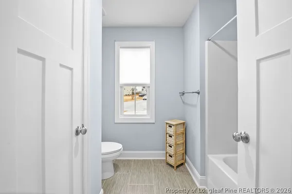 a bathroom with a granite countertop sink a toilet and shower