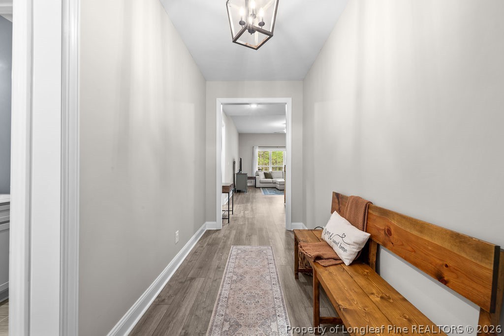 405 Turriff Way Cameron, NC 28326 - Photo 3 of 43 a hallway with wooden floor and a chandelier