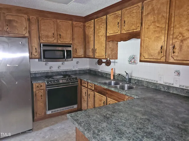a kitchen with stainless steel appliances granite countertop a sink stove and microwave
