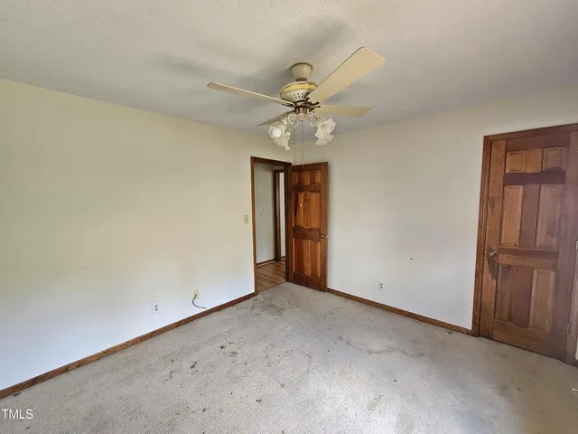 an empty room with fan and windows