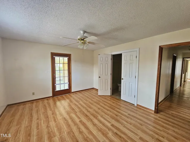 a view of an empty room with window and wooden floor