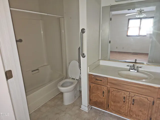 a spacious bathroom with a granite countertop sink toilet and shower