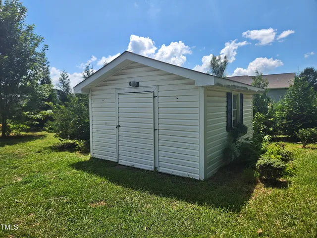 a view of backyard with potted plants and large tree