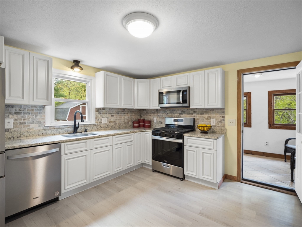 167 Karen Circle Holliston, MA 01746 - Photo 11 of 30 a kitchen with stainless steel appliances granite countertop a stove sink and microwave