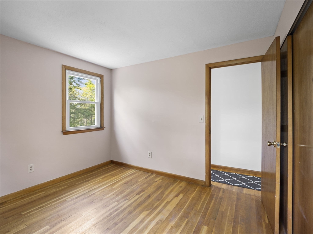 167 Karen Circle Holliston, MA 01746 - Photo 22 of 30 a view of an empty room with wooden floor and a window