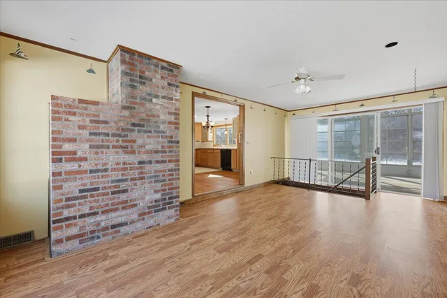 a view of empty room with wooden floor and fireplace