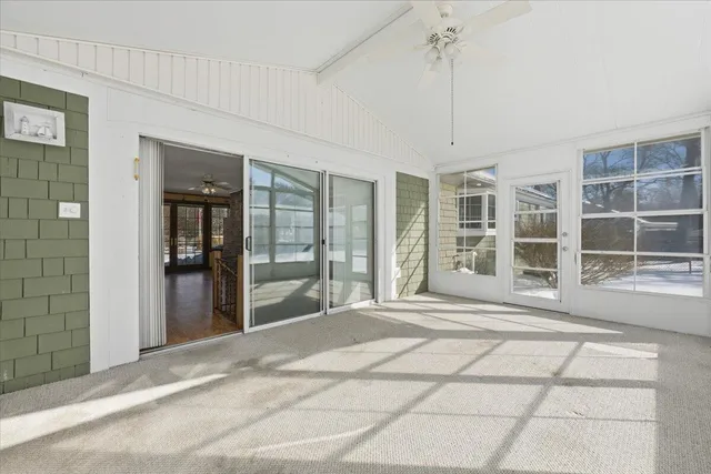 a view of a hallway with windows and chandelier