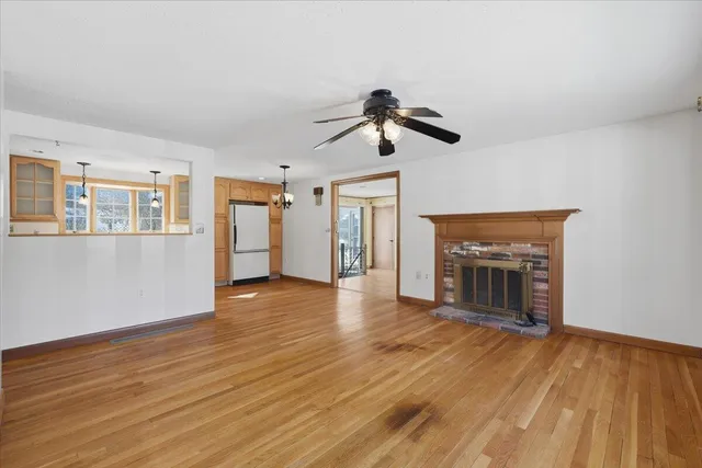 a view of empty room with wooden floor and fireplace