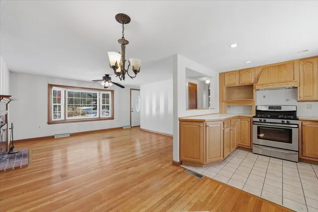a kitchen with granite countertop a stove and a wooden floor
