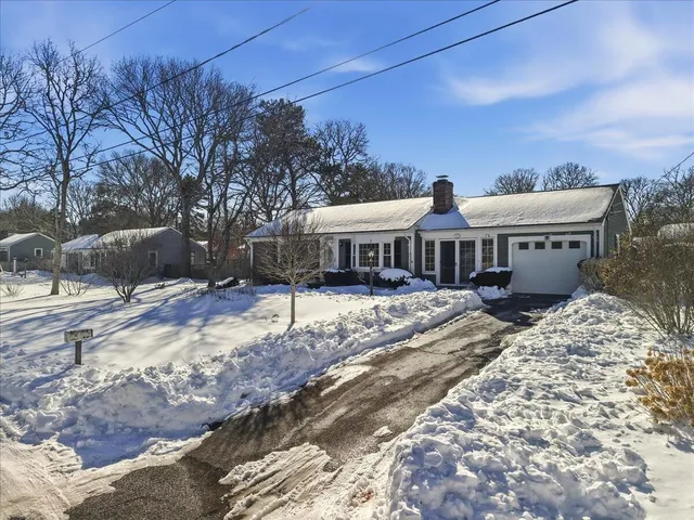 a view of a house with a yard covered in snow