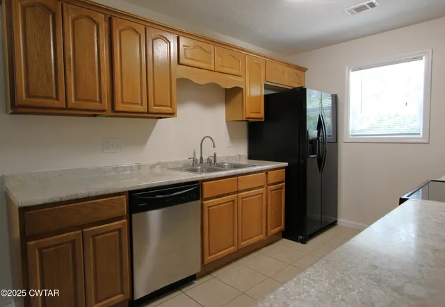 a kitchen with stainless steel appliances granite countertop a refrigerator and cabinets