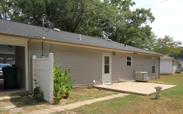 a backyard of a house with table and chairs
