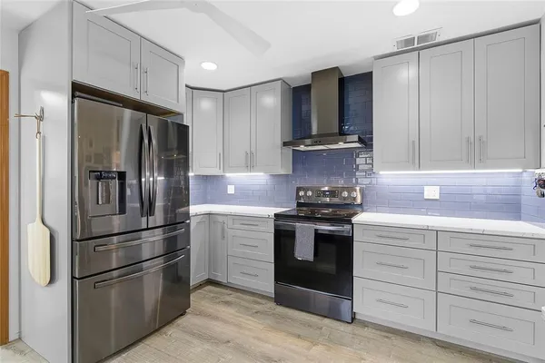 a kitchen with stainless steel appliances granite countertop a refrigerator stove and sink