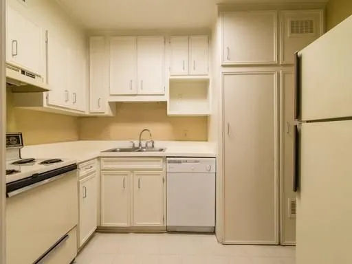 a kitchen with a sink a refrigerator and cabinets