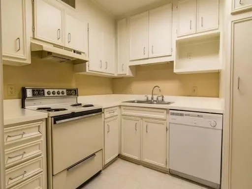a kitchen with granite countertop white cabinets and white appliances
