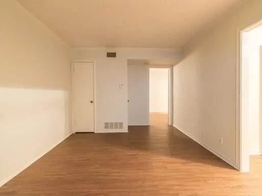 a view of an empty room and wooden floor