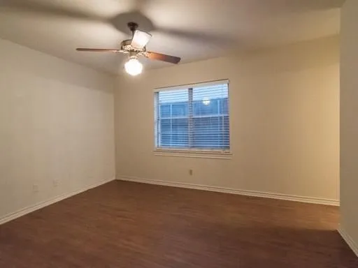 a view of an empty room with a chandelier fan