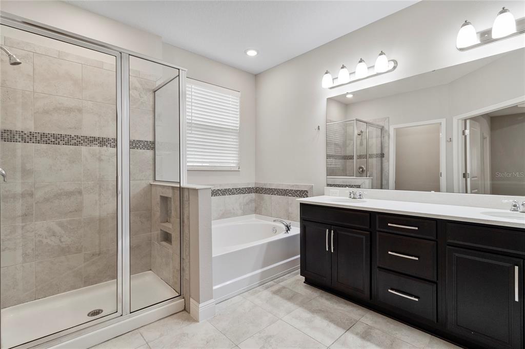 8764 Powder Ridge Trail Windermere, FL 34786 - Photo 25 of 43 a spacious bathroom with a tub sink shower and mirror