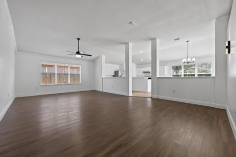 a view of an empty room with wooden floor