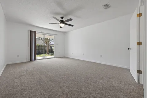 a view of a livingroom with a ceiling fan and window