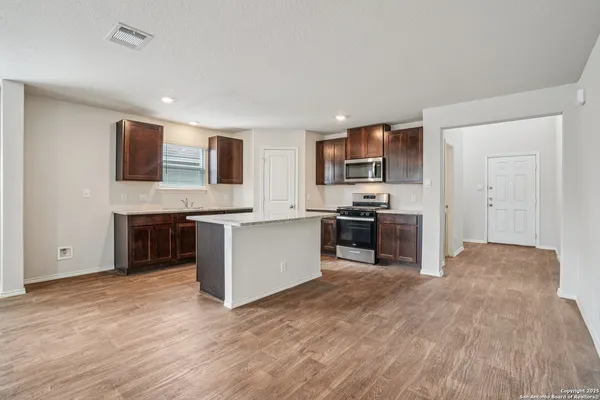 a large kitchen with stainless steel appliances granite countertop a stove a sink and a refrigerator