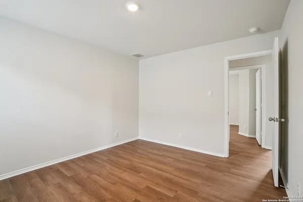 a view of an empty room with wooden floor