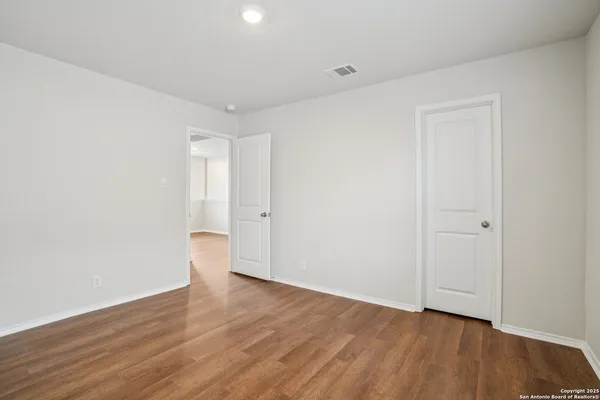 a view of an empty room with wooden floor