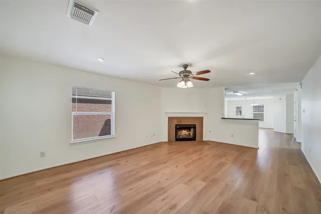 an empty room with windows and fireplace