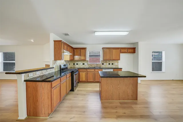 a kitchen with stainless steel appliances granite countertop a stove and a sink