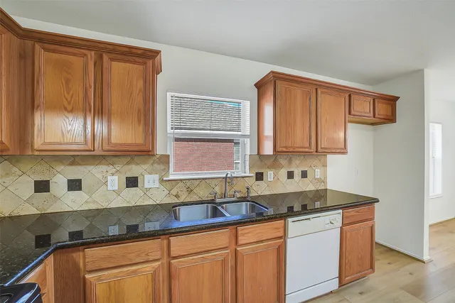 a kitchen with stainless steel appliances granite countertop wooden cabinets a sink and dishwasher