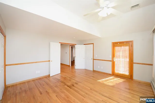 a view of an empty room with wooden floor