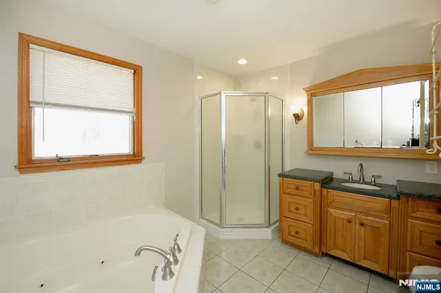 a bathroom with a tub sink and mirror
