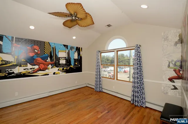 a view of a room with gym equipment and wooden floor