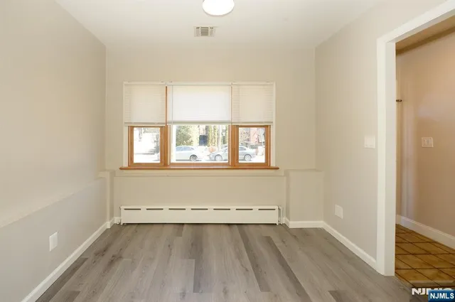 an empty room with a hardwood and windows