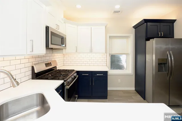a kitchen with stainless steel appliances a refrigerator sink and microwave