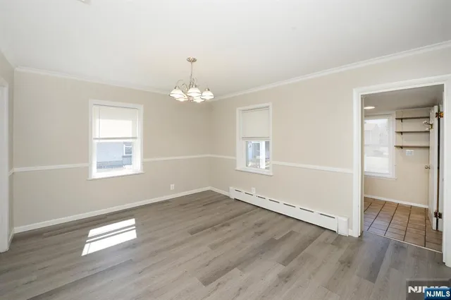 an empty room with wooden floor and window