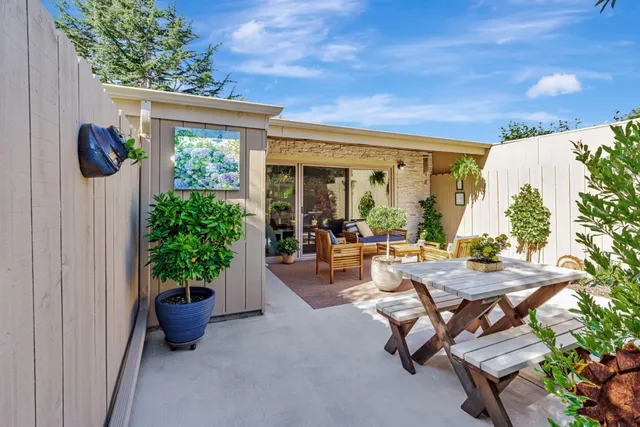a view of a patio with table and chairs potted plants with wooden fence