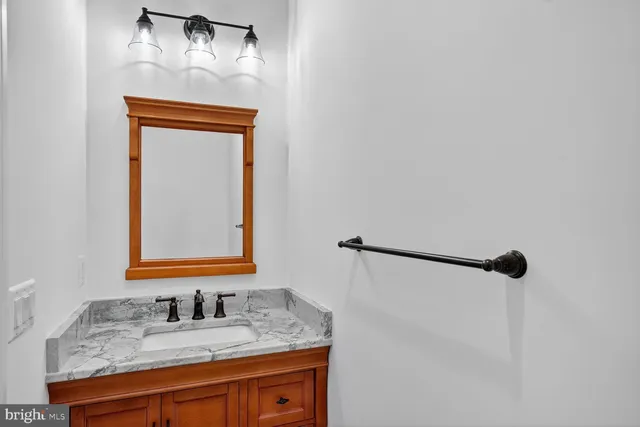 a bathroom with a granite countertop sink and a mirror