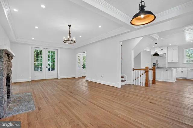 a view of empty room with wooden floor and windows