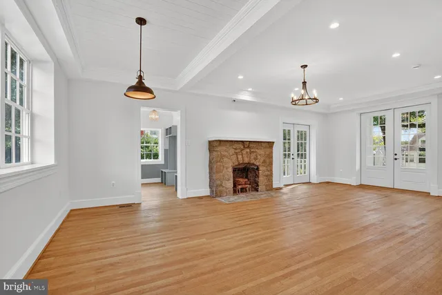 a view of empty room with wooden floor fireplace and windows
